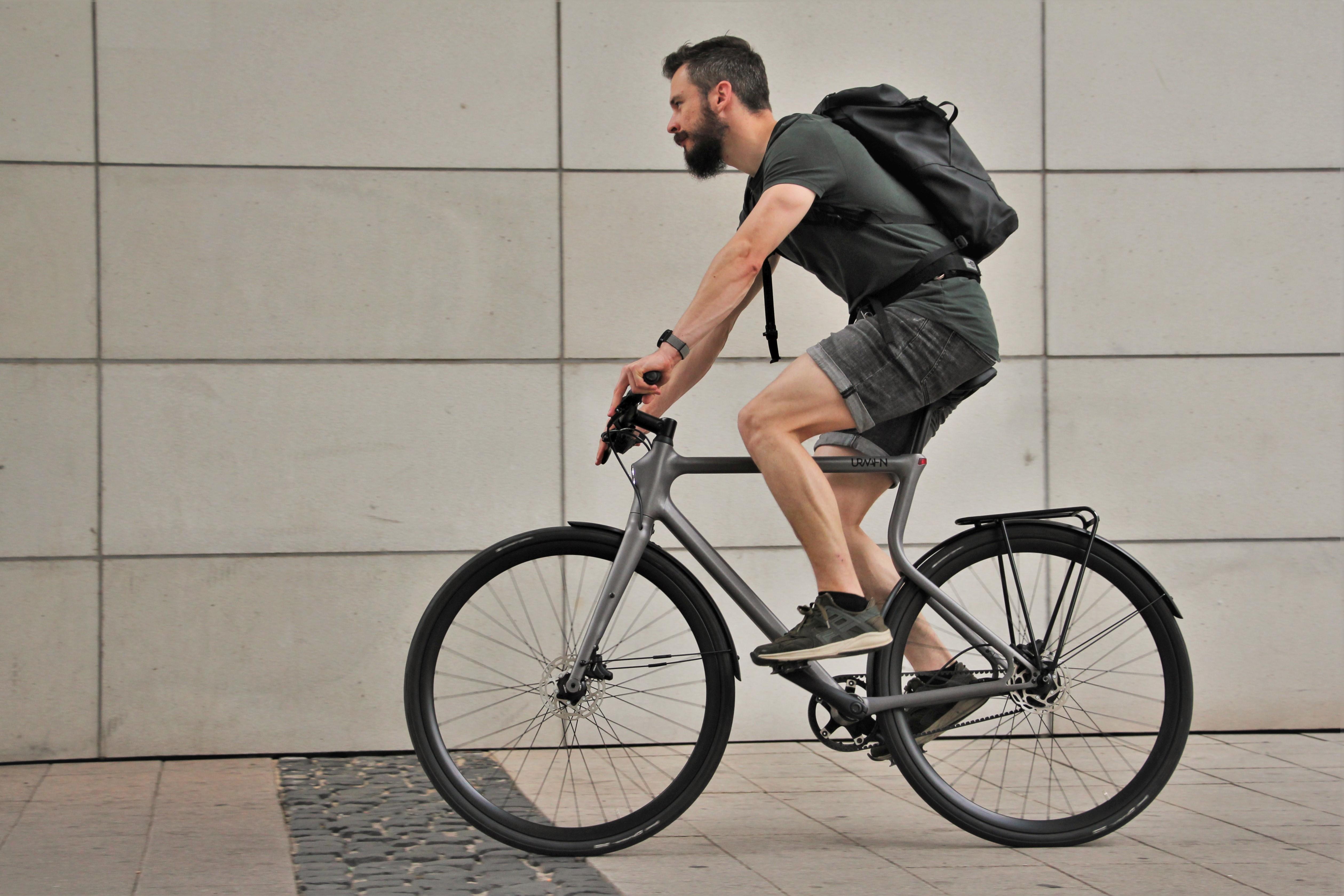 Radfahrer fährt auf einem grauen Urwahnbike